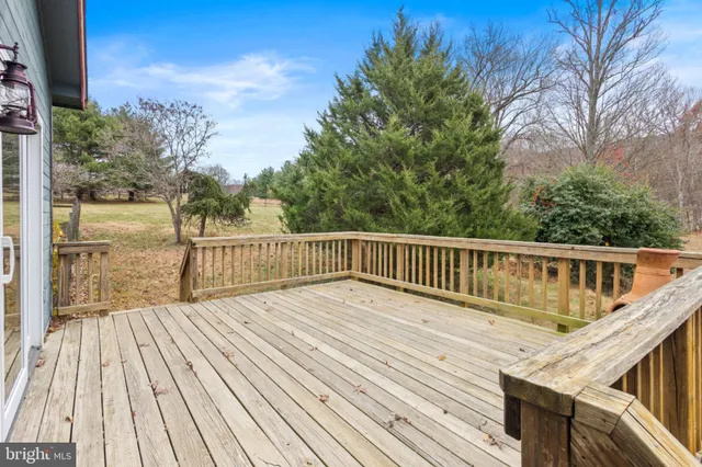 a backyard of a house with wooden deck and furniture