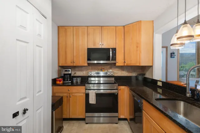 a kitchen with stainless steel appliances a stove a sink and a microwave
