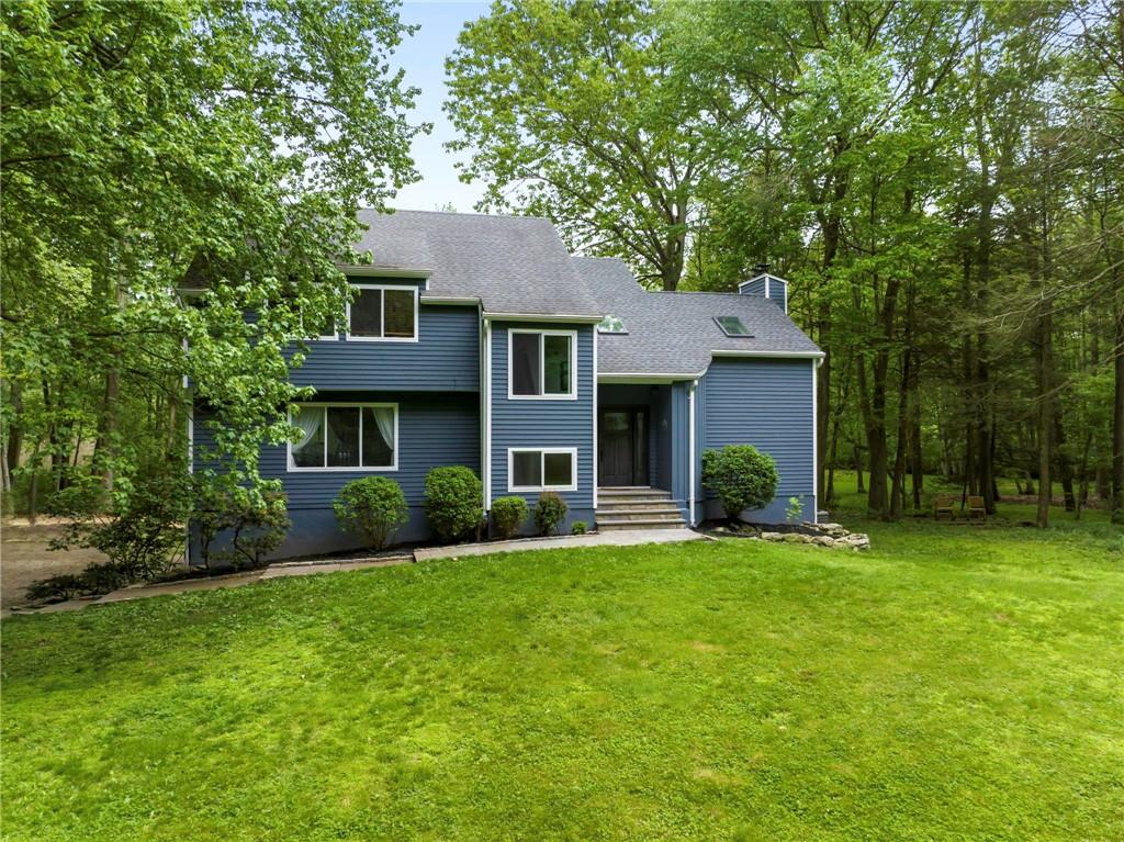 50 White Birch Road Pound Ridge, NY 10576 - Photo 1 of 1 a front view of a house with a yard and trees