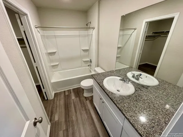 a bathroom with a granite countertop sink toilet and shower