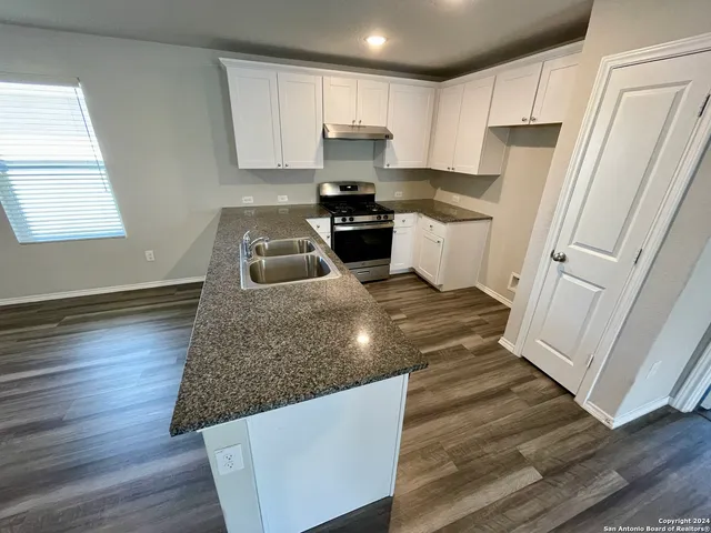 a kitchen with granite countertop a refrigerator and a stove