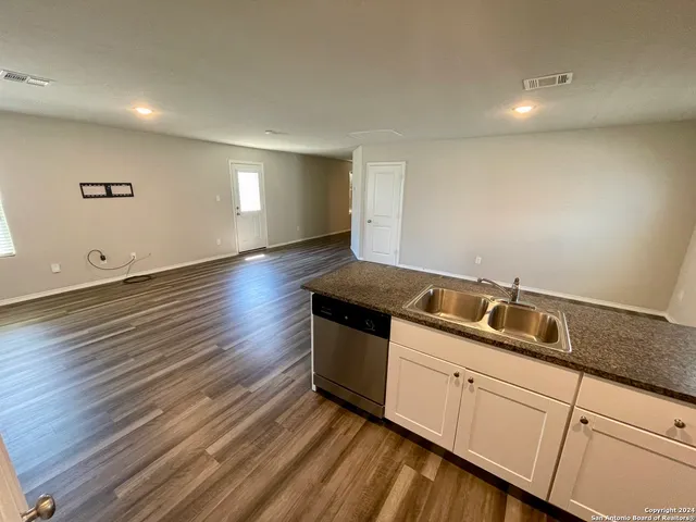 a kitchen with a sink and wooden floor