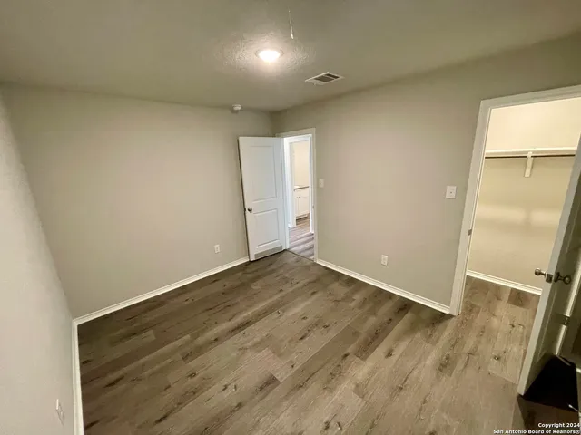 an empty room with wooden floor and a window