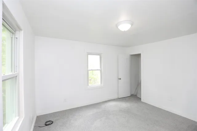 an empty room with windows and closet