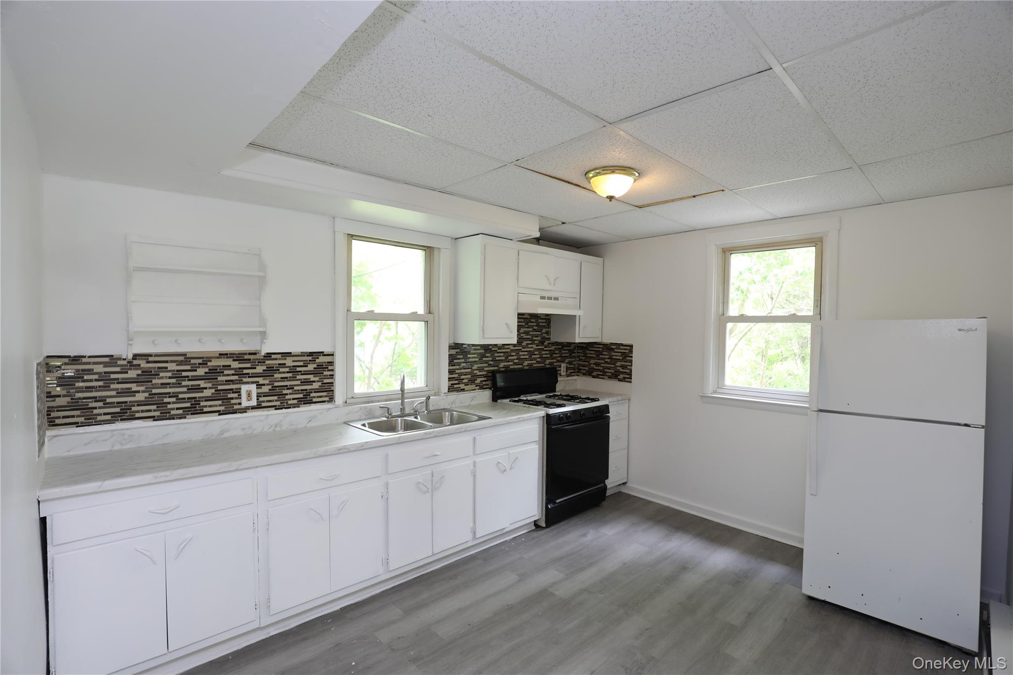 17 Rear Chapel Street Ellenville, NY 12428 - Photo 6 of 24 a kitchen with granite countertop a sink stove and refrigerator
