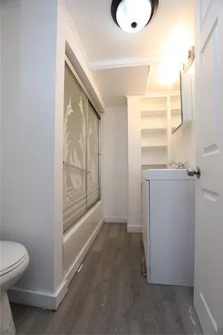 a bathroom with a granite countertop sink a toilet and a window