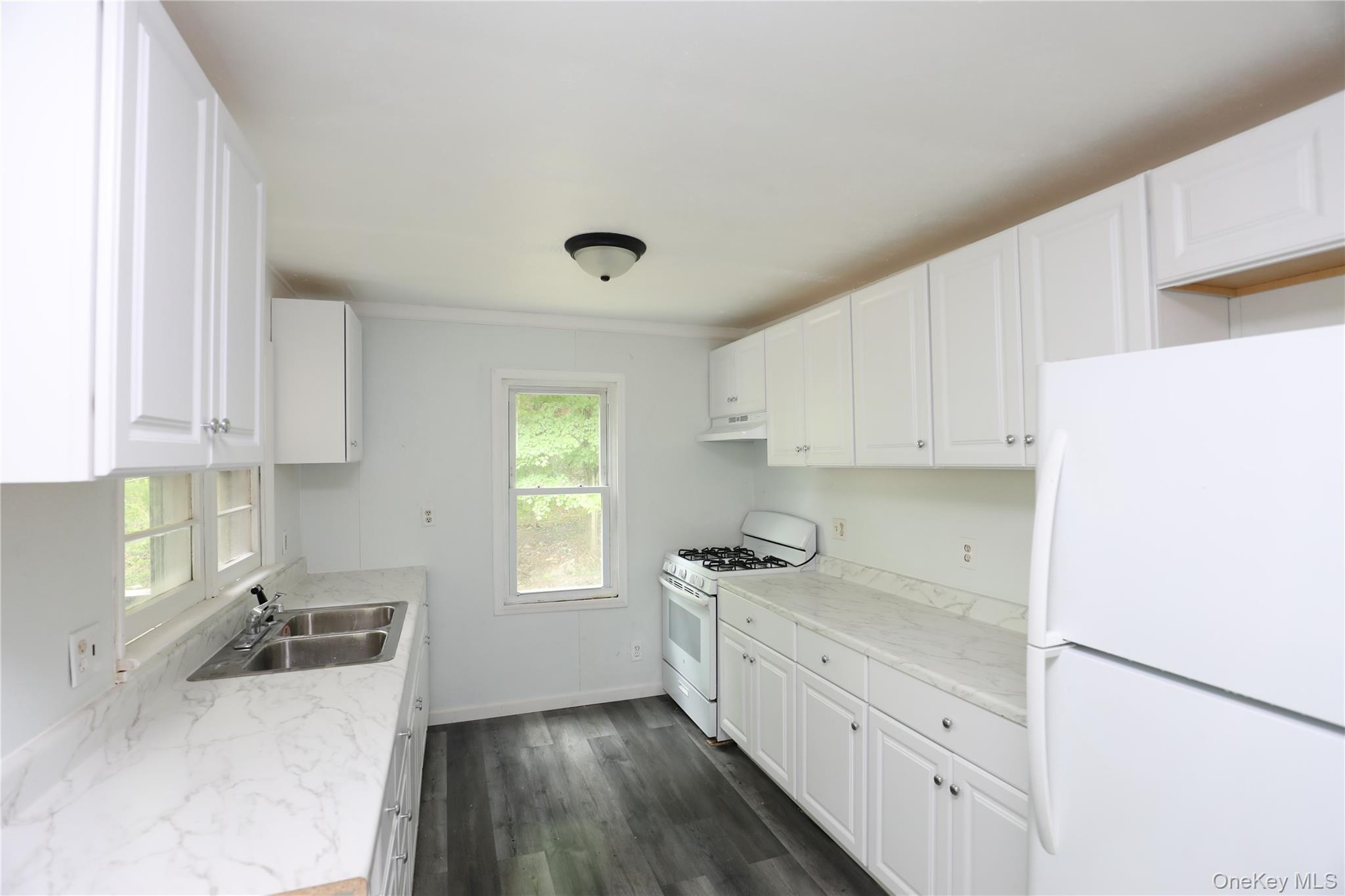 17 Rear Chapel Street Ellenville, NY 12428 - Photo 9 of 24 a kitchen with granite countertop white cabinets and white appliances