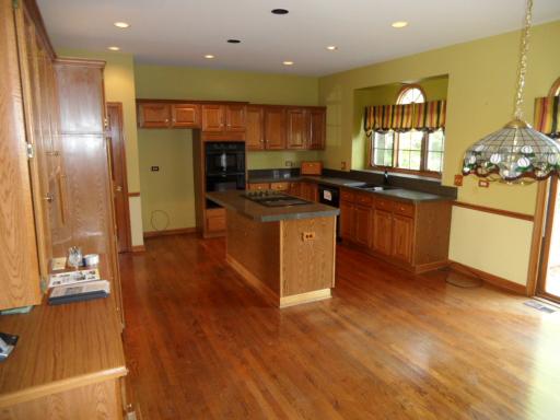 5N585 Dunham Trails Road Wayne, IL 60184 - Photo 5 of 9 a kitchen with stainless steel appliances granite countertop a refrigerator a sink dishwasher a stove and a dining table with wooden floor