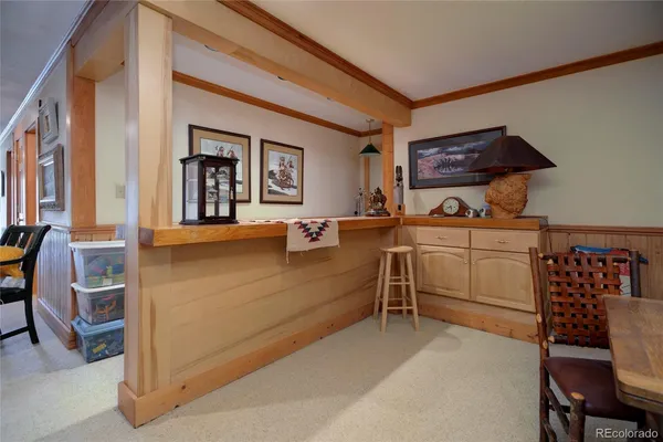 a spacious bedroom with a bed a large window with table and chairs