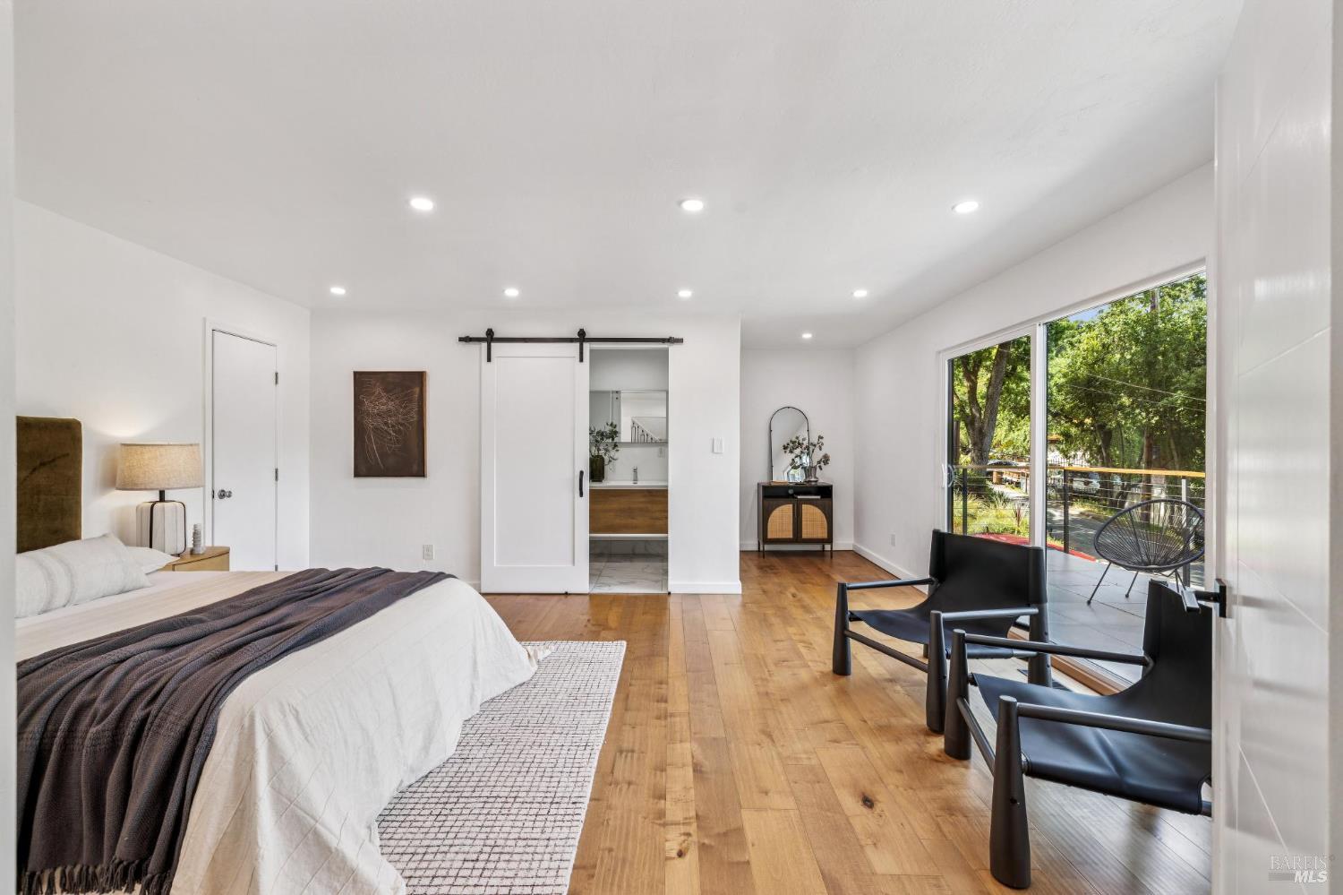 227 Coleman Drive San Rafael, CA 94901 - Photo 4 of 36 a spacious bedroom with a bed a couch and a table in it