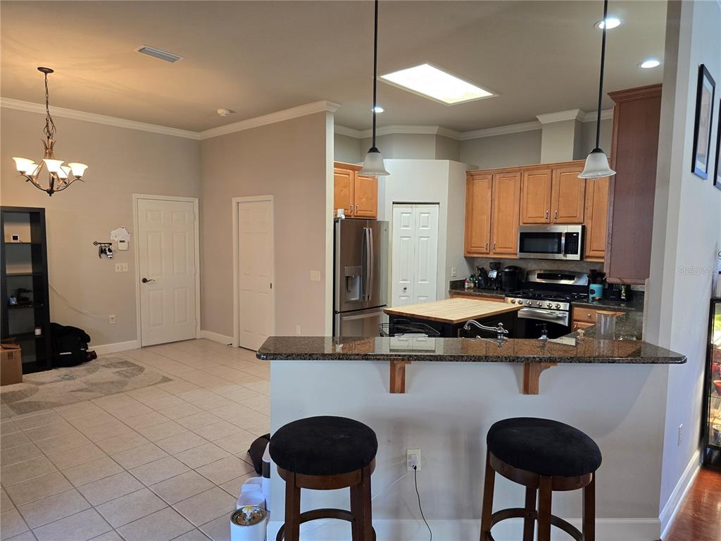 8613 Southwest 76th Place Gainesville, FL 32608 - Photo 11 of 30 a kitchen with stainless steel appliances granite countertop a sink a stove a refrigerator cabinets and dining table