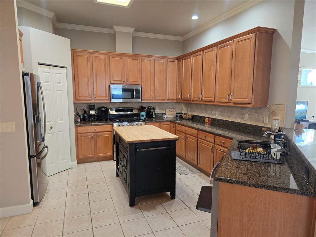8613 Southwest 76th Place Gainesville, FL 32608 - Photo 12 of 30 a kitchen with stainless steel appliances granite countertop a stove top oven a refrigerator a sink and dishwasher