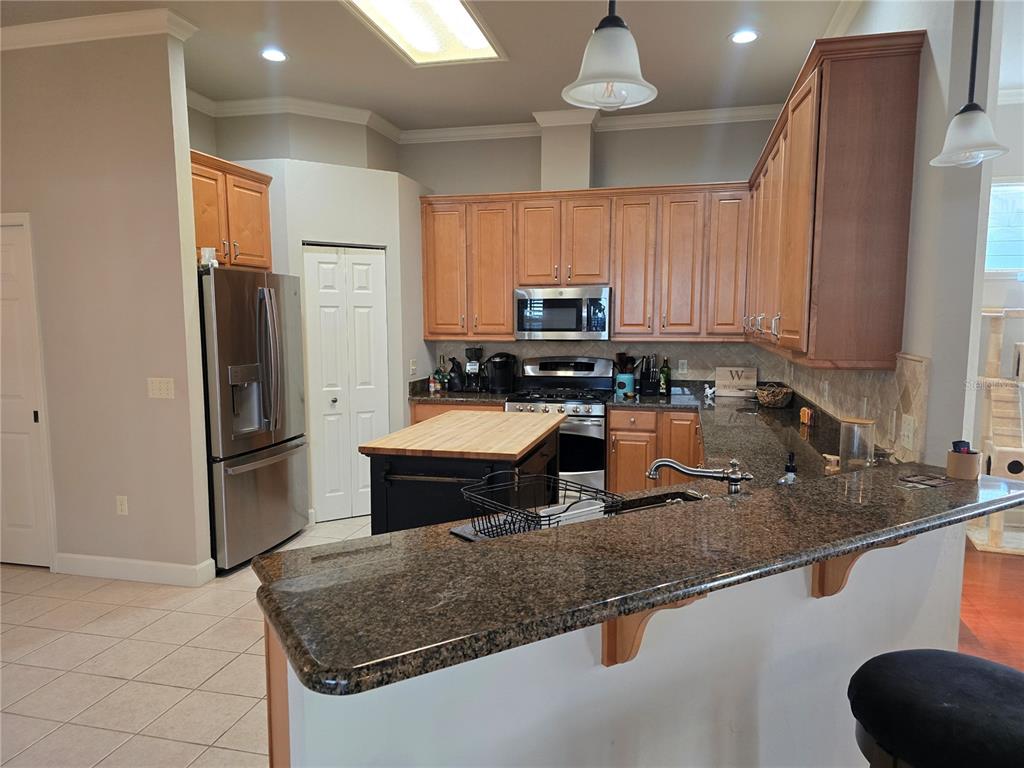 8613 Southwest 76th Place Gainesville, FL 32608 - Photo 13 of 30 a kitchen with stainless steel appliances granite countertop a sink a stove and a refrigerator