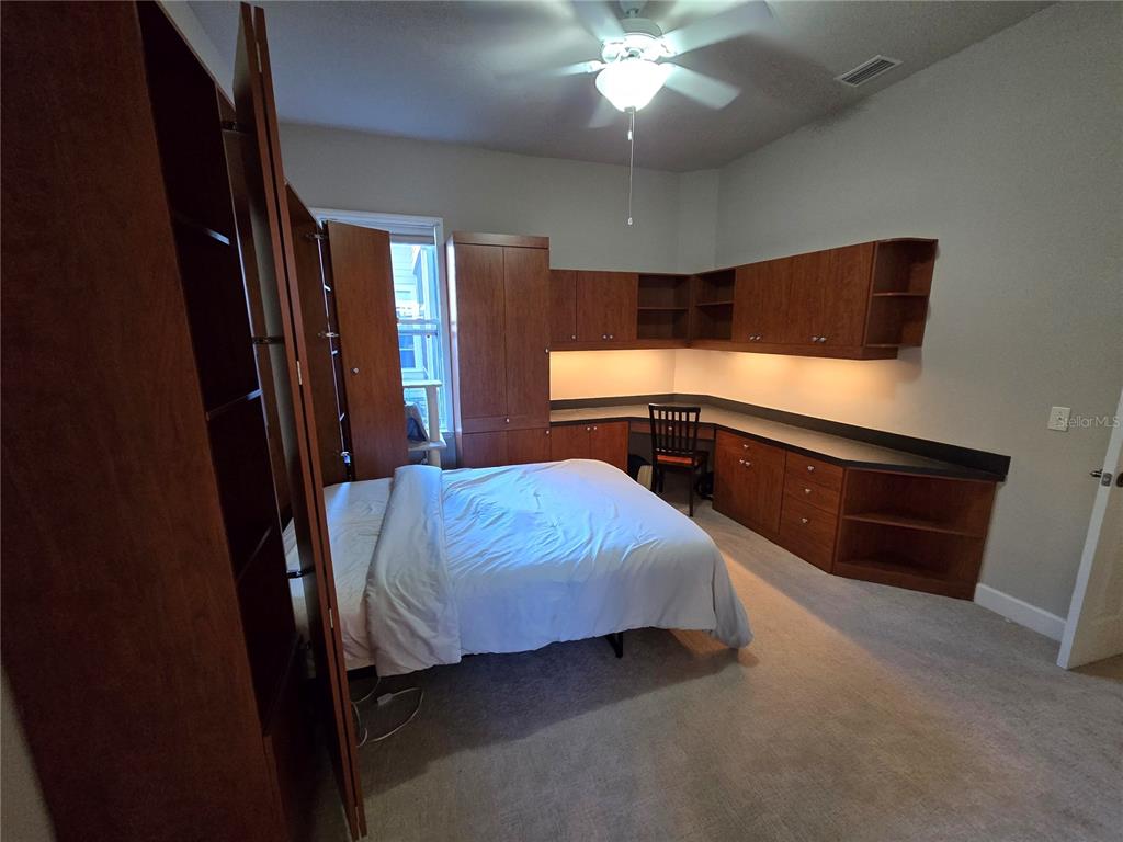 8613 Southwest 76th Place Gainesville, FL 32608 - Photo 18 of 30 a bedroom with a bed and a chandelier