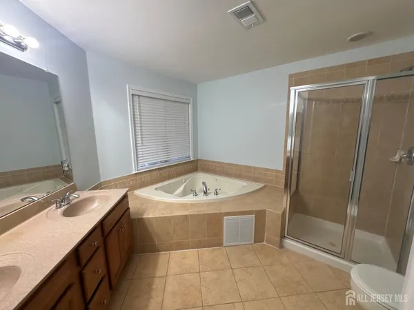 a bathroom with a tub sink and mirror