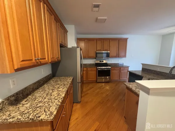 a kitchen with stainless steel appliances granite countertop a refrigerator a stove top oven a sink and dishwasher