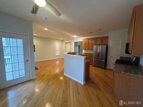 a kitchen with stainless steel appliances granite countertop a refrigerator a stove and a wooden floors