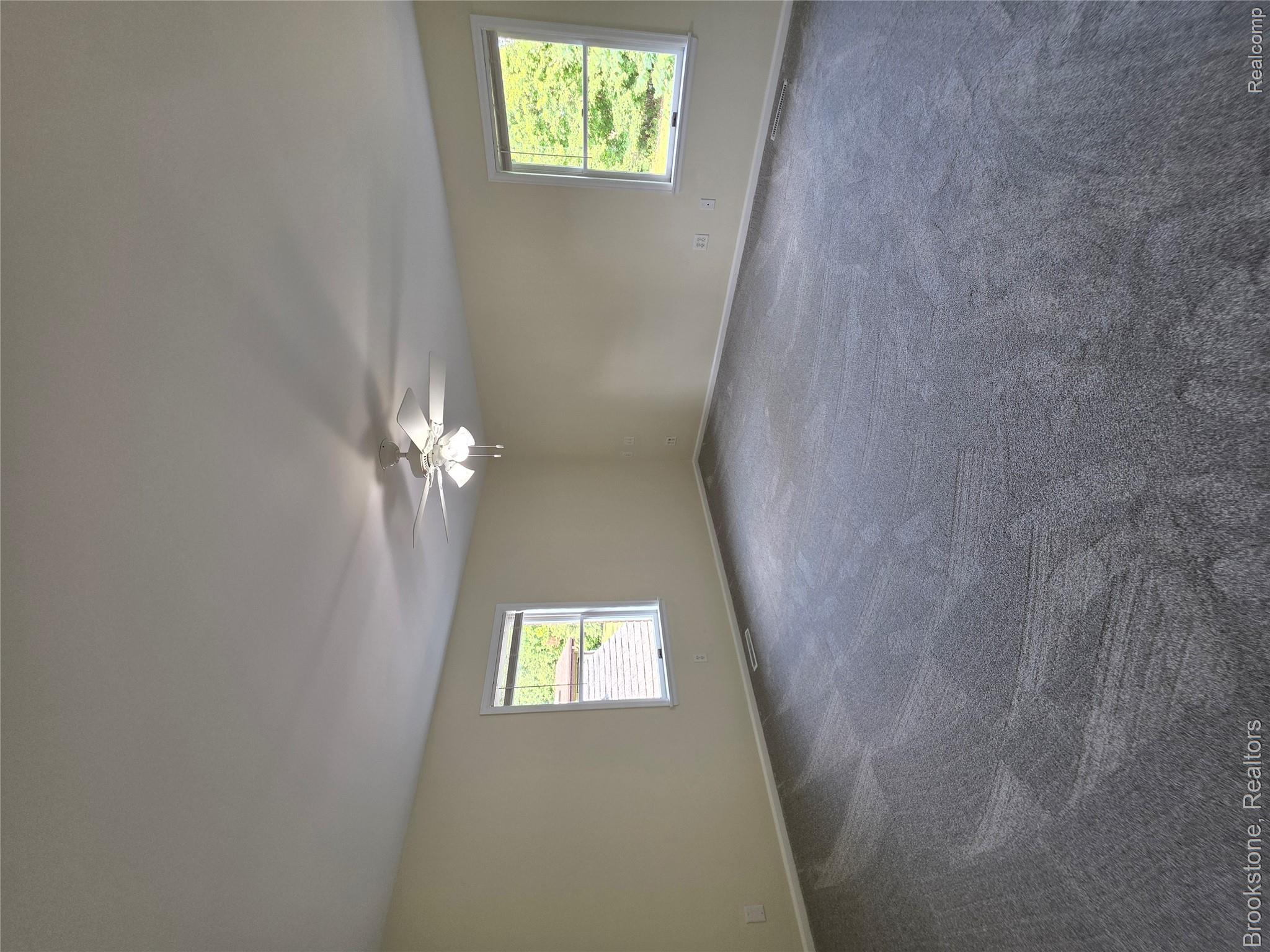 1210 Springborrow Drive Flint, MI 48532 - Photo 26 of 34 Spacious bedroom with neutral wall finishes, plush carpeting, ceiling fan with integrated lighting, and dual windows providing natural light