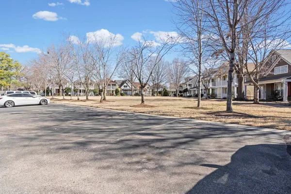 a living room with furniture and a dining table with wooden floor