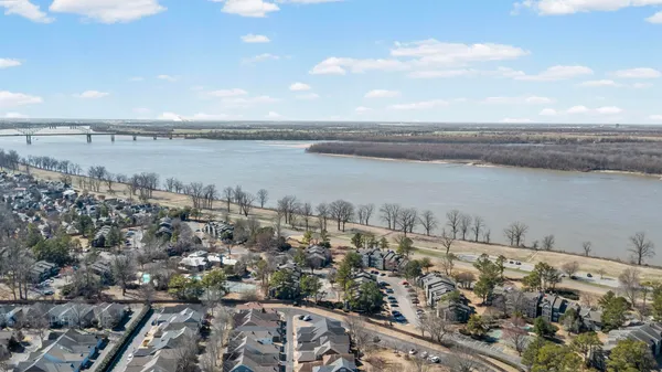 a kitchen with stainless steel appliances kitchen island granite countertop a refrigerator a stove top oven a sink dishwasher and white cabinets with wooden floor