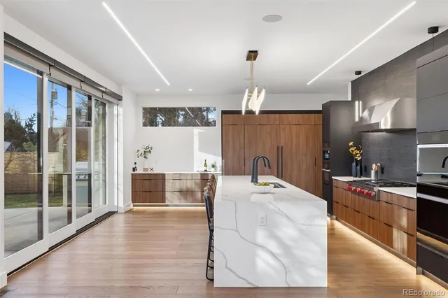a kitchen with kitchen island a counter top space a sink and stainless steel appliances