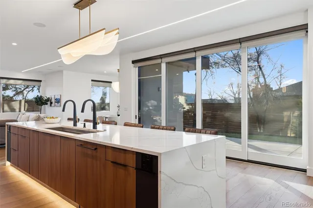 a large kitchen with kitchen island a sink and a large window