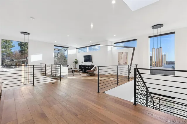 a view of a living room and kitchen with furniture wooden floor and windows