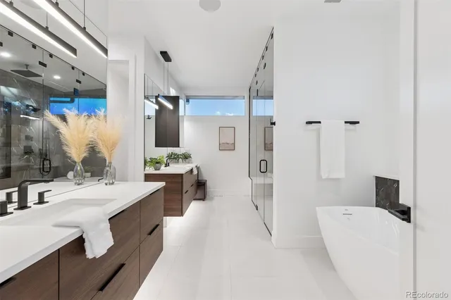 a spacious bathroom with a double vanity sink a mirror and a shower