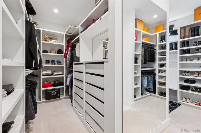 a view of walk in closet with clothes and shoes