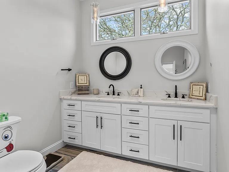 15 Riverview Avenue, Unit D Mashpee, MA 02649 - Photo 16 of 33 a bathroom with a granite countertop toilet a sink and a mirror