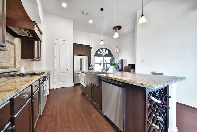 a kitchen with a sink a counter space appliances and cabinets