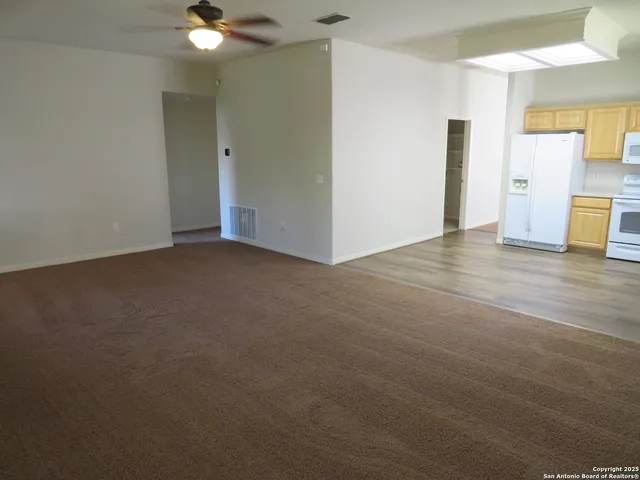 a view of an empty room with closet and a window