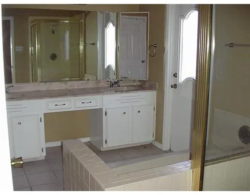 a spacious bathroom with a mirror and a sink