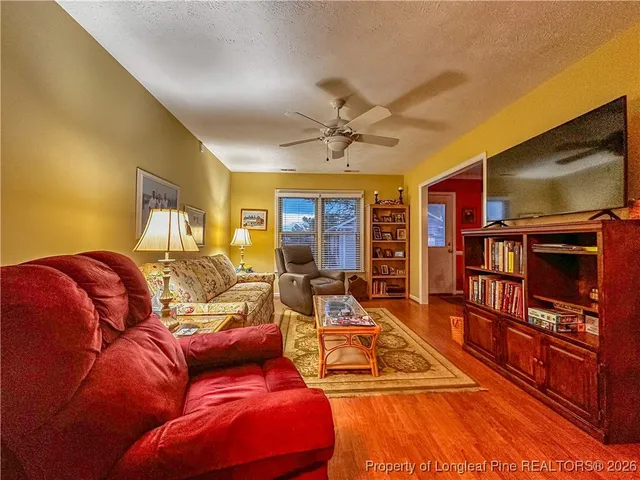 a living room with furniture a flat screen tv and a book shelf