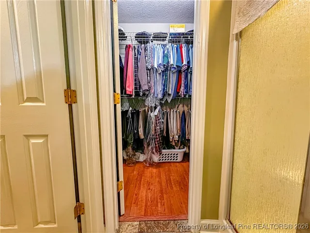 a view of walk in closet with clothes