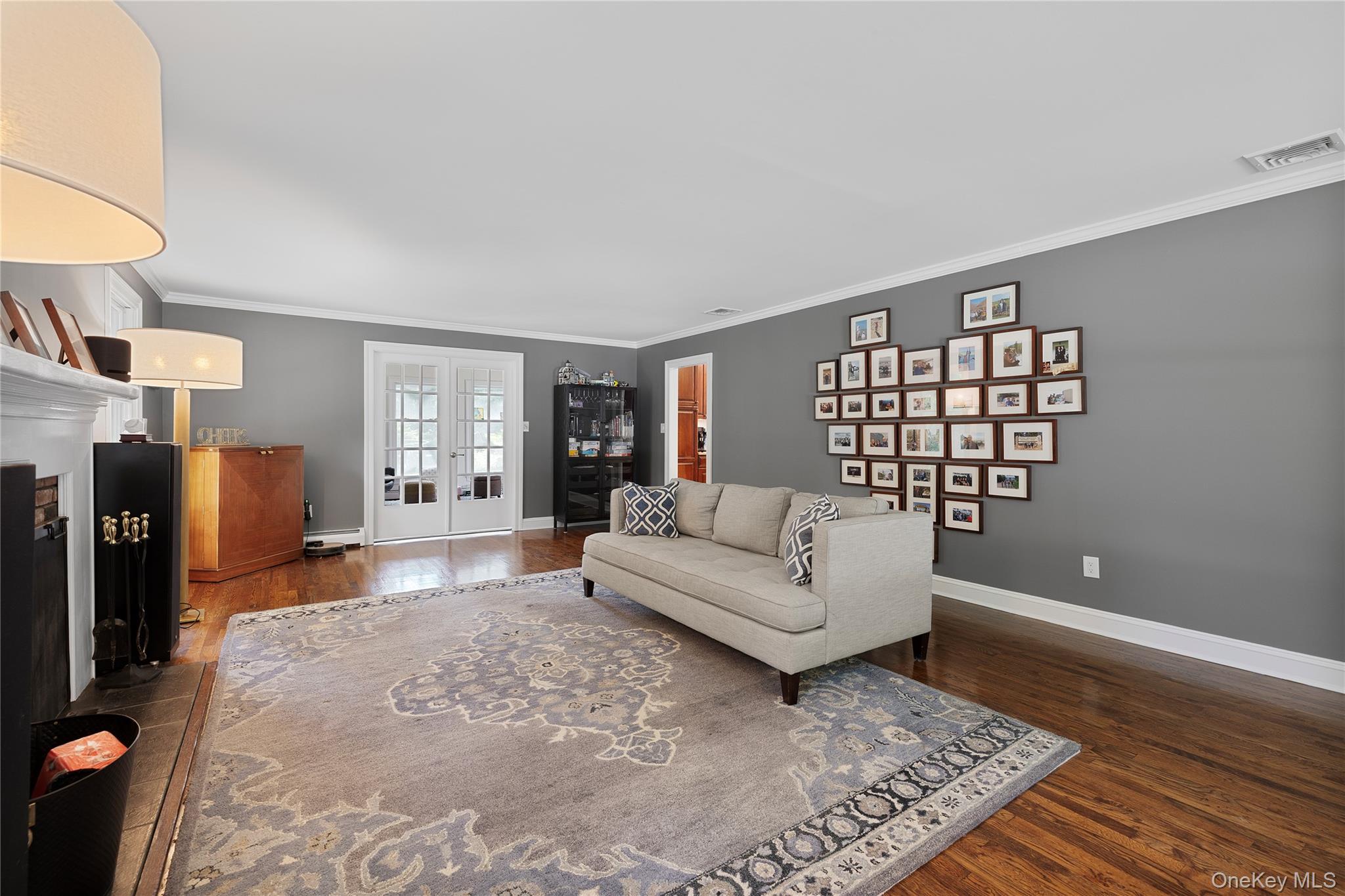 9 Three Sisters Road St. James, NY 11780 - Photo 11 of 36 Formal living room featuring wood-finish flooring, white crown molding, and white baseboards