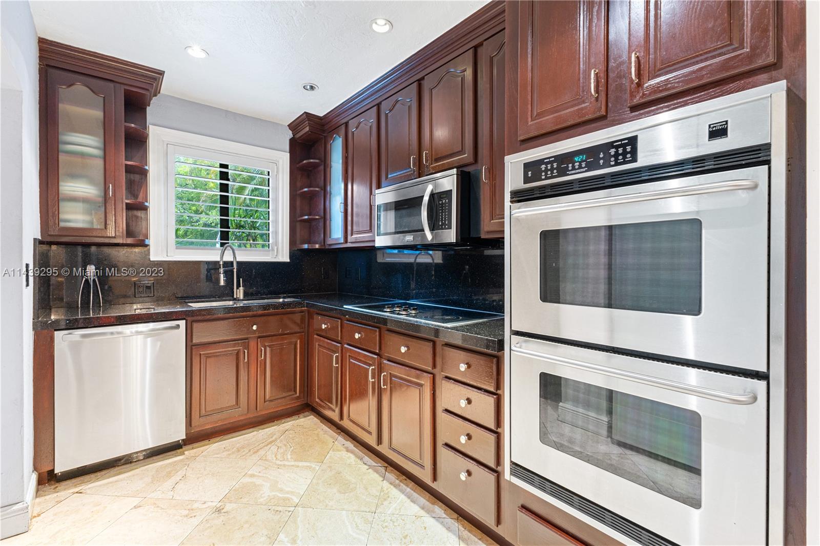 201 Southwest 24th Road Miami, FL 33129 - Photo 6 of 18 a kitchen with granite countertop cabinets stainless steel appliances and a window