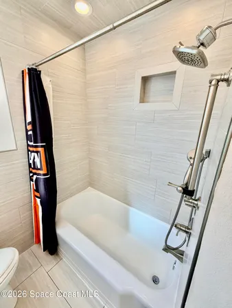 a bathroom with a tub a toilet and a shower