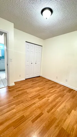 an empty room with wooden floor and natural light