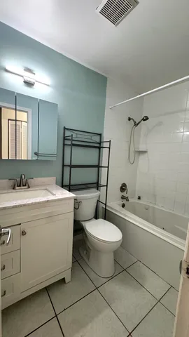 a bathroom with a sink toilet a mirror and bathtub