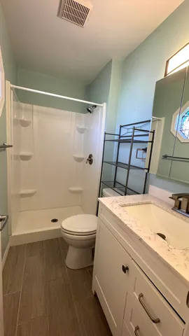 a bathroom with a sink a toilet and shower