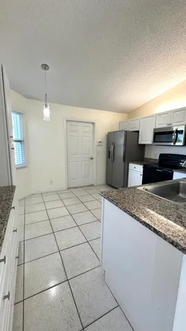 a spacious bathroom with a granite countertop sink and a mirror