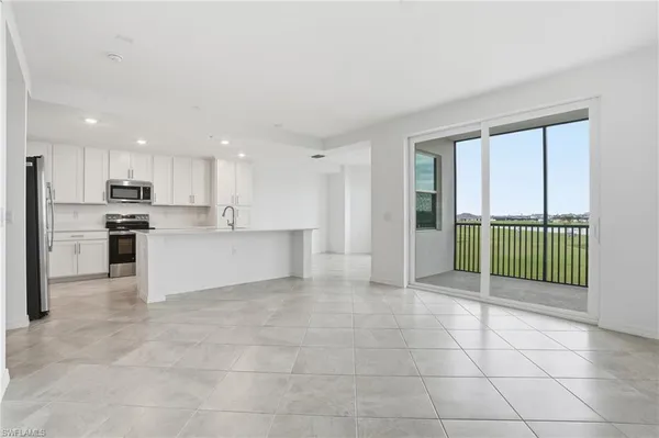 a large kitchen with stainless steel appliances kitchen island a large counter top and a refrigerator