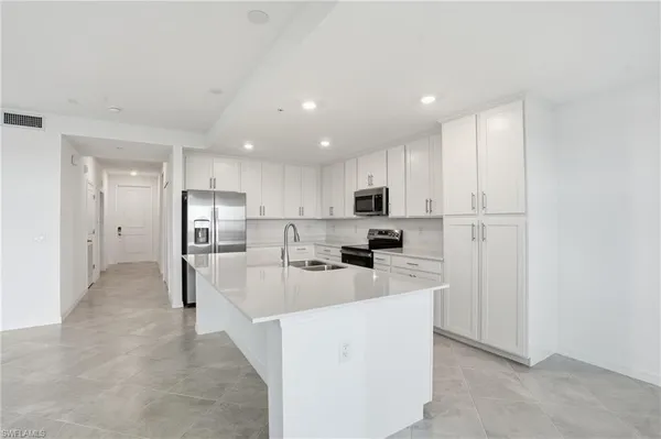 a kitchen with white cabinets and stainless steel appliances