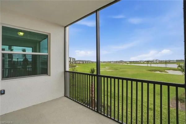 a view of a swimming pool with lawn chairs and a big yard