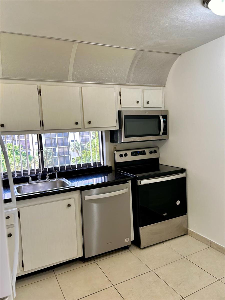 16919 North Bay Road, Unit 509 Sunny Isles Beach, FL 33160 - Photo 26 of 43 a kitchen with stainless steel appliances a stove a sink and a microwave