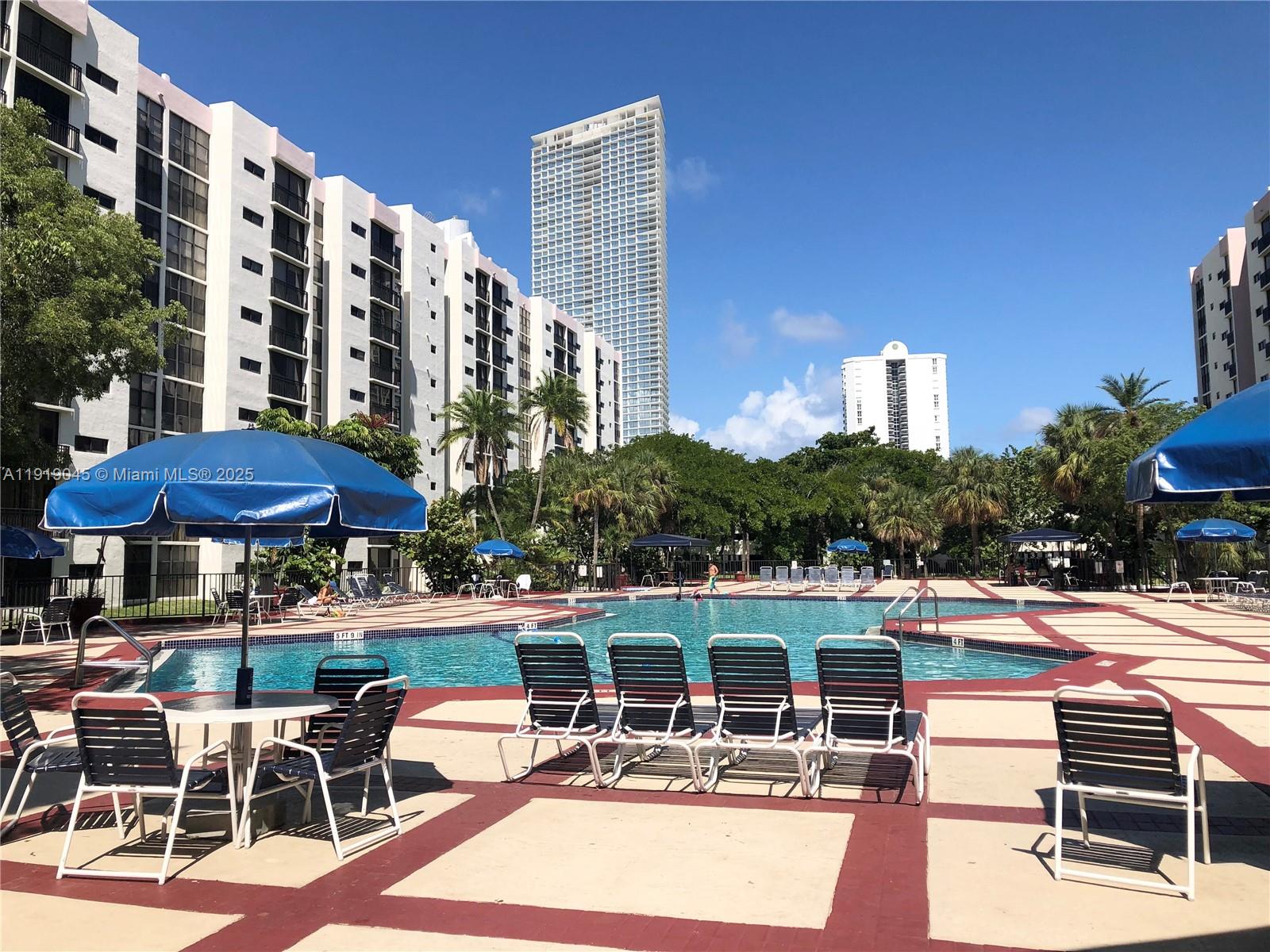 16919 North Bay Road, Unit 509 Sunny Isles Beach, FL 33160 - Photo 7 of 43 a patio with a table and chairs under an umbrella