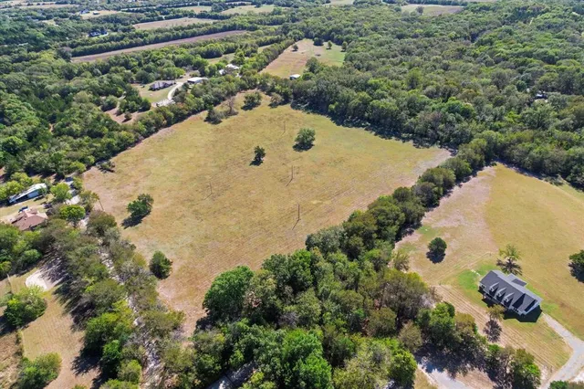 an aerial view of a house with a yard and lake view