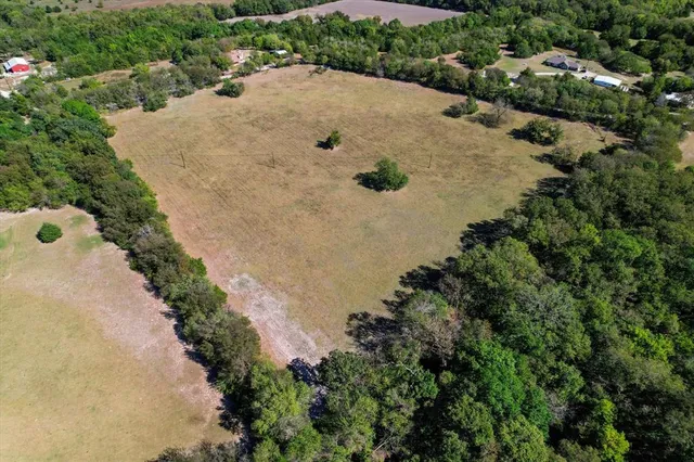 an aerial view of a house with a yard and lake view