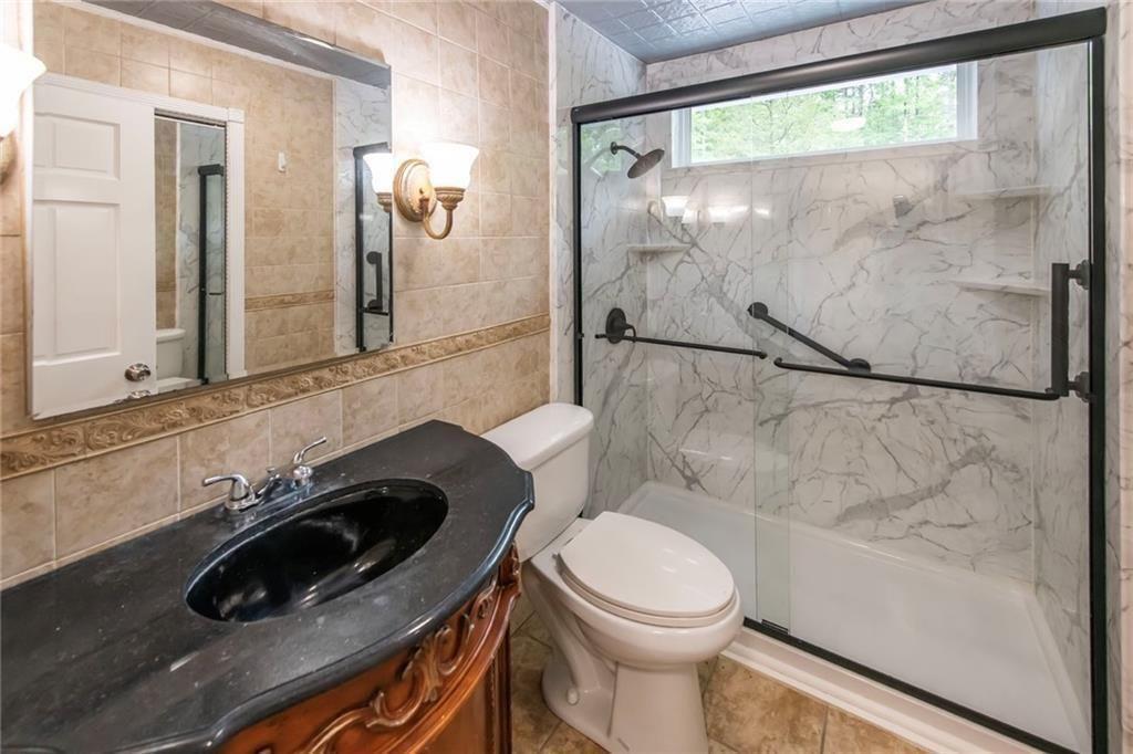 3819 Mason Creek Road Winston, GA 30187 - Photo 23 of 54 a bathroom with a sink a toilet and shower